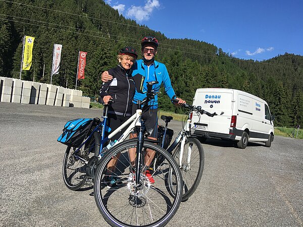 Ein Radler Paar vor dem Donau Touristik Transporter