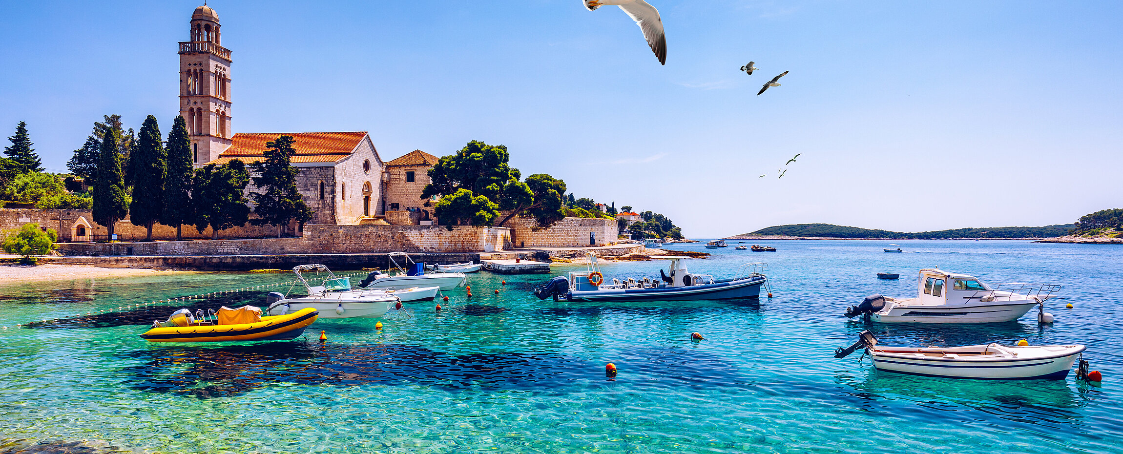 Hafen von Hvar in Kroatien mit Booten, Möwen und Meer.