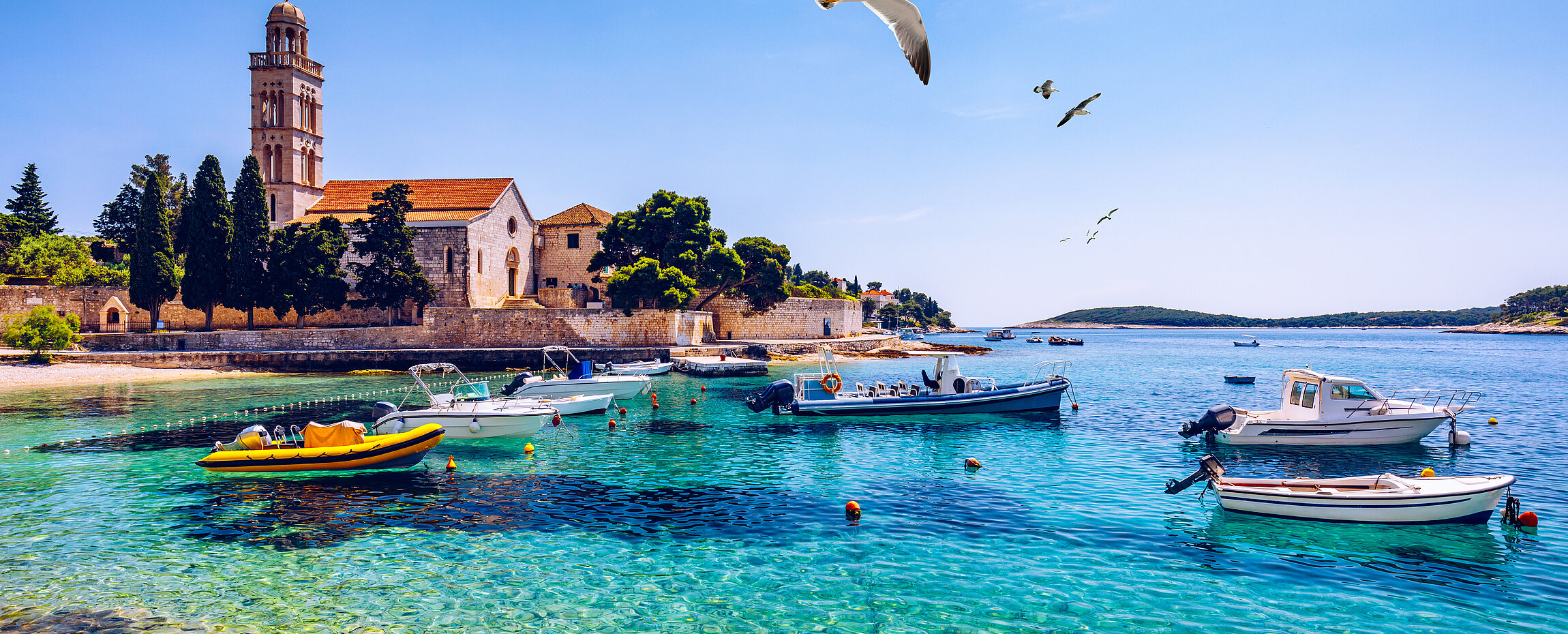 Hafen von Hvar in Kroatien mit Booten, Möwen und Meer.