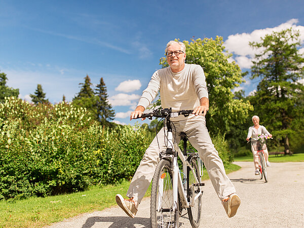 zwei Senioren am Rad bergabfahrend 