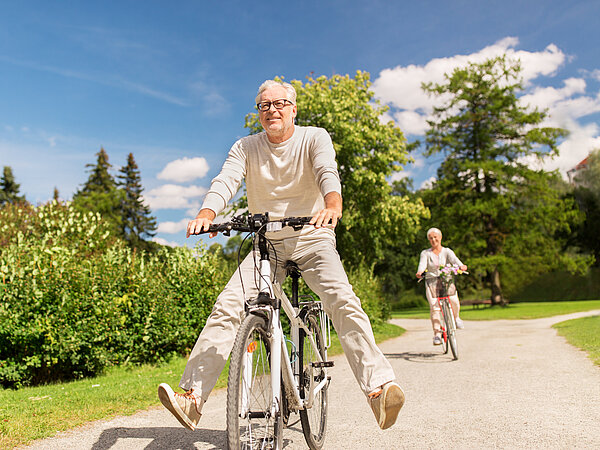 zwei Senioren am Rad bergabfahrend 