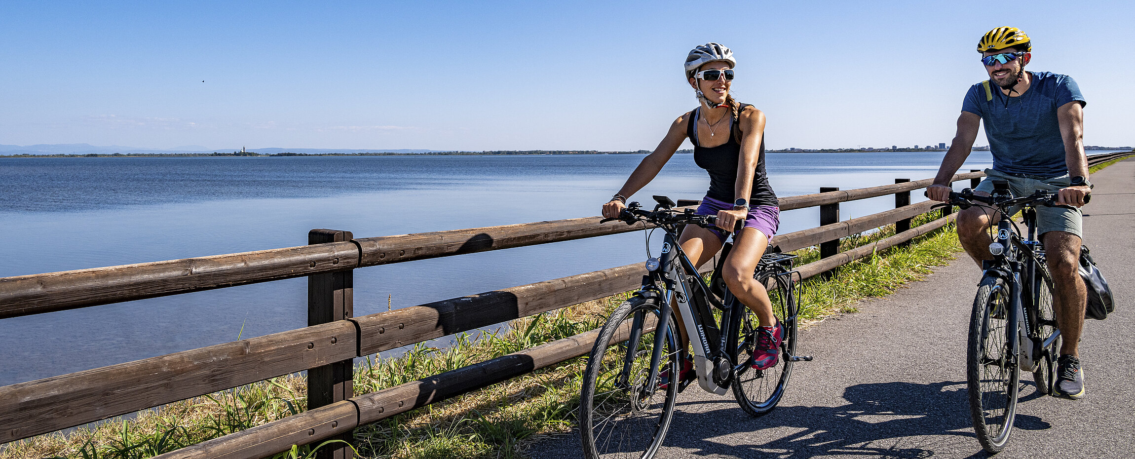 Radfahrer auf dem Alpe-Adria-Radweg bei Grado, Italien, mit Blick aufs Meer.