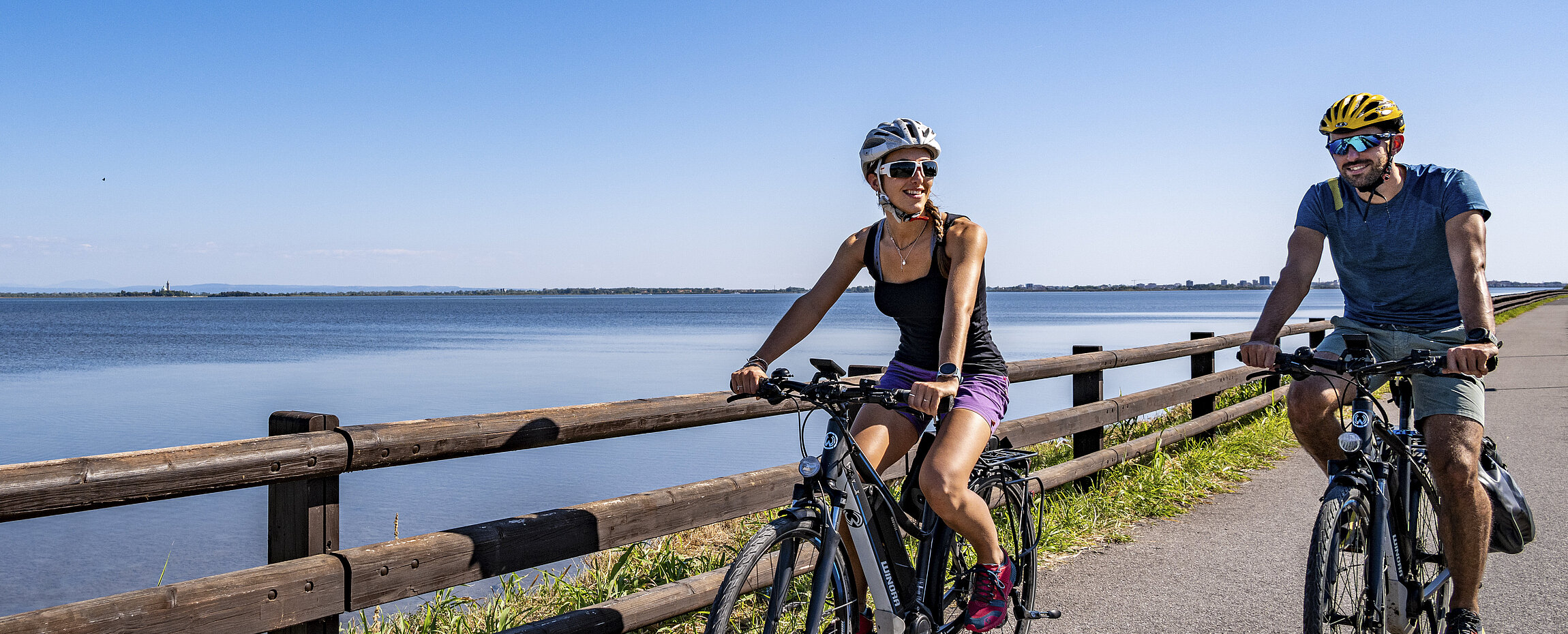 Radfahrer auf dem Alpe-Adria-Radweg bei Grado, Italien, mit Blick aufs Meer.