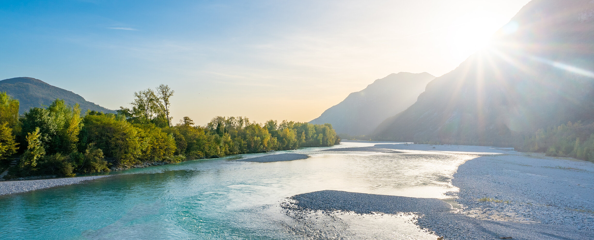 Sonnenuntergang hinter den Bergen über dem Tagliamento bei Venzone in Friaul-Julisch Venetien.