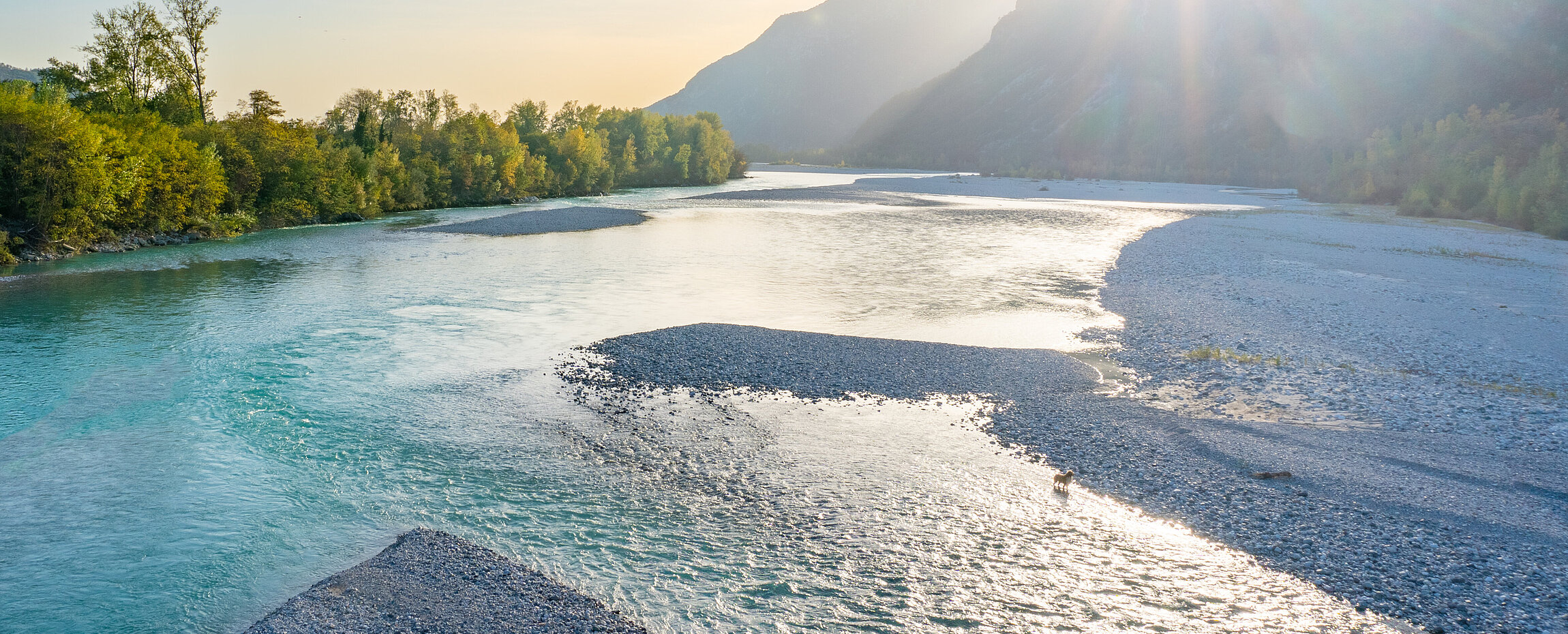 Sonnenuntergang hinter den Bergen über dem Tagliamento bei Venzone in Friaul-Julisch Venetien.