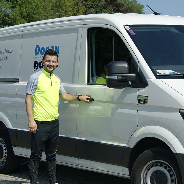 Mann vor dem Donau Touristik Transporter