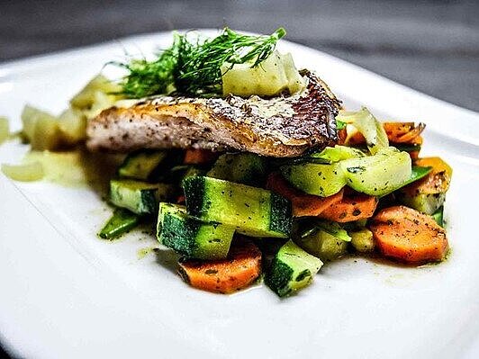 Gegrilltes Karpfenfilet auf buntem Gemüse